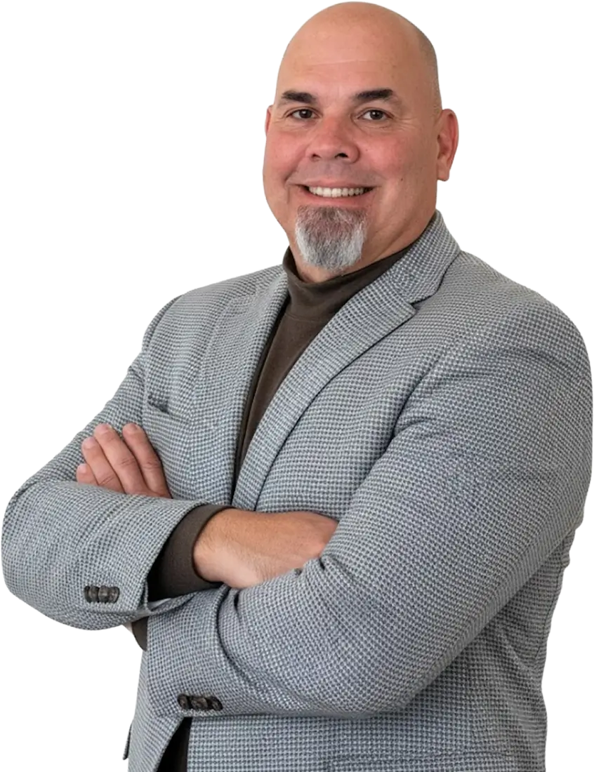Paul Chavez wearing a grey suit smiling and crossing his arms